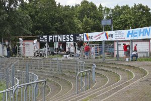 Maler Herr und Helfer streichen Bandenständer im Kreuzeichestadion