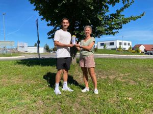 Tanja Keppler von ultraSPORTS übergibt dem Co-Trainer des SSV Reutlingen Getränke-Shaker und Trinkflaschen